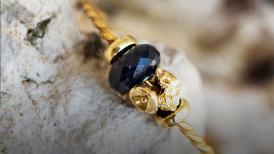 Twisted guld armring med onyx kugle og blomster kugle i guld